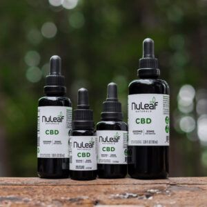 assorted CBD oil bottles on a log